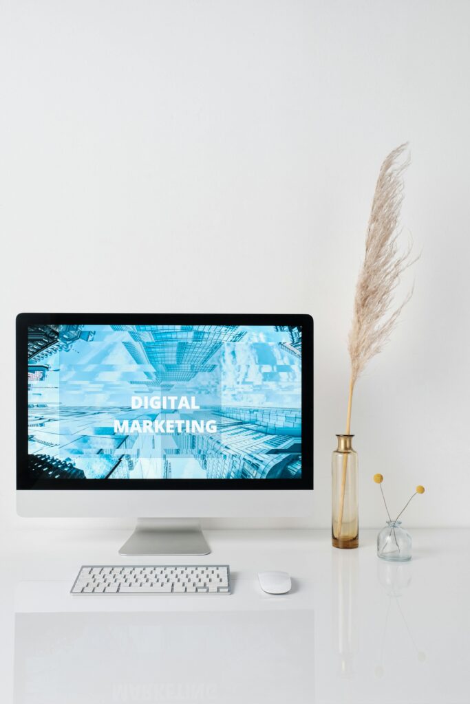 Modern workspace featuring a monitor displaying digital marketing graphics on a minimalist desk.